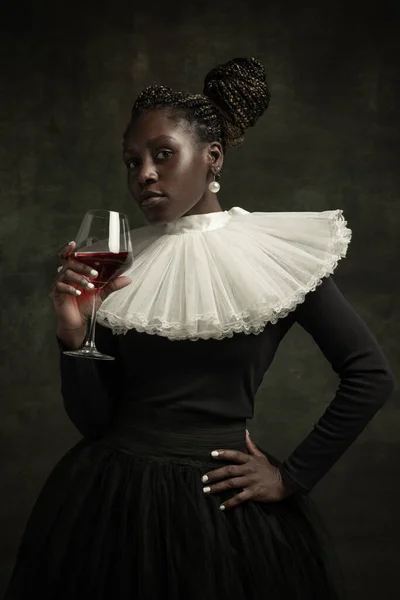 Porträt einer mittelalterlichen afrikanischen jungen Frau in schwarzem Vintage-Kleid mit großem weißen Kragen, die isoliert auf dunkelgrünem Hintergrund posiert. Prost — Stockfoto