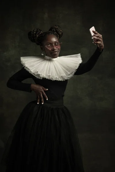 Siyah, beyaz yakalı, koyu yeşil arka planda yalnız poz veren ortaçağ Afrikalı genç kadın portresi. Selfie çekiyorum. — Stok fotoğraf