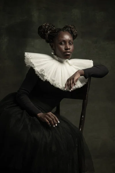 非洲中世纪年轻女子的画像，身穿黑色复古服装，大白领，与深绿色背景隔离. — 图库照片