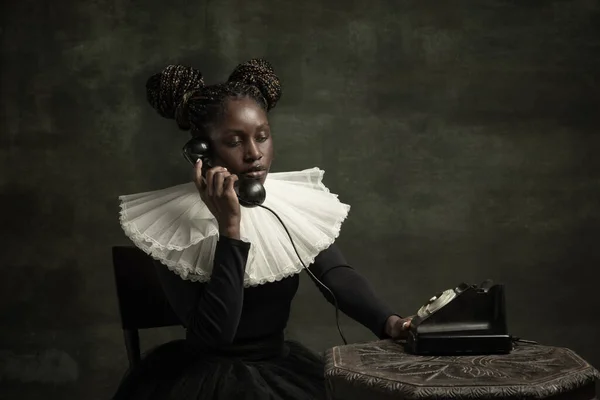 Porträt einer mittelalterlichen afrikanischen jungen Frau in schwarzem Vintage-Kleid mit großem weißen Kragen, die isoliert auf dunkelgrünem Hintergrund posiert. — Stockfoto