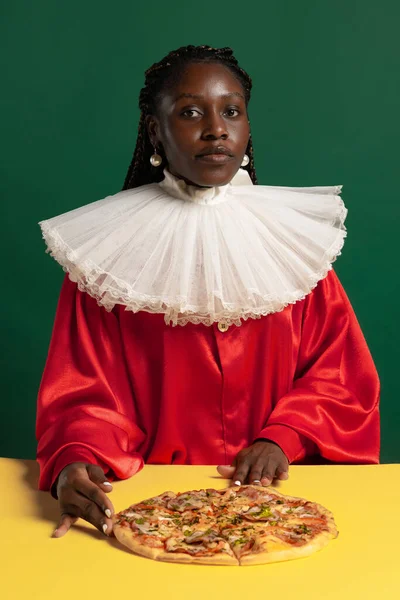 Yeşil arka planda izole edilmiş büyük beyaz yakalı parlak kırmızı elbiseli bir Afrikalı genç kadın. Devir, moda, mizah, reklam karşılaştırması kavramı. — Stok fotoğraf