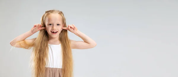 Mooi klein meisje in moderne stijlvolle jurk poseren geïsoleerd op witte studio achtergrond. Gelukkige jeugd concept. — Stockfoto