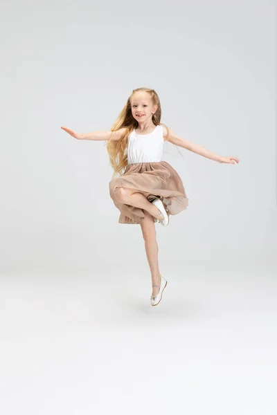 Beautiful little girl in modern stylish dress posing isolated on white studio background. Happy childhood concept. — Stock Photo, Image