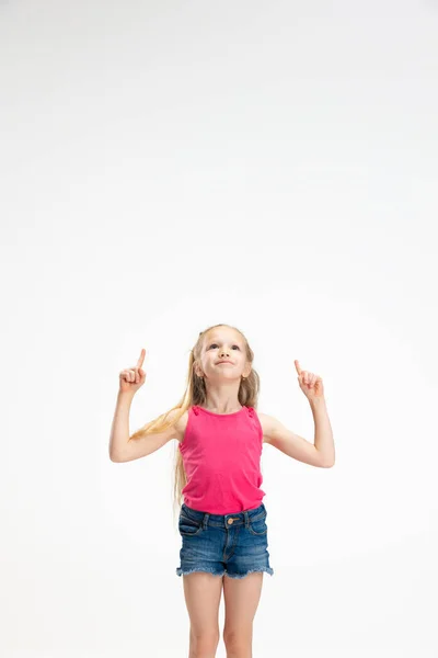 Portrait de demi-longueur de belle petite fille en vêtements décontractés posant isolée sur fond de studio blanc. Concept d'enfance heureuse. — Photo