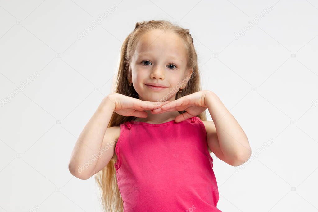 Close-up beautiful little girl in casual clothes posing isolated on white studio background. Happy childhood concept.