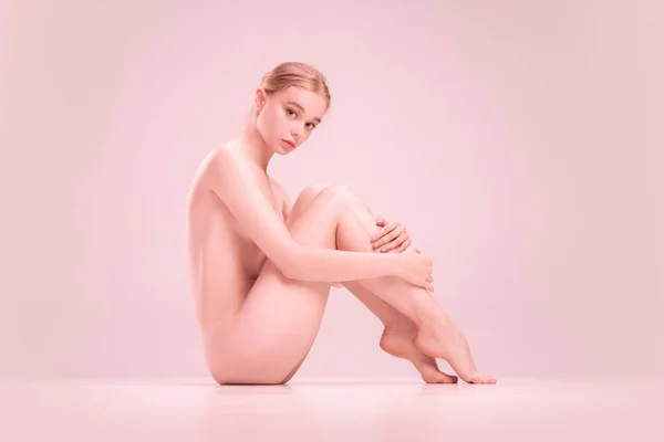 Slim young naked beautiful girl on pink background. Concept of beauty, purity, tenderness and grace. — Stock Photo, Image