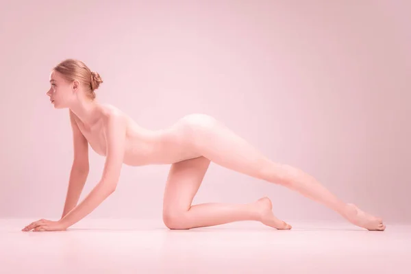 Graciosa frágil jovem menina bonita nua posando isolado no fundo do estúdio rosa. Conceito de beleza, pureza, ternura e graça. — Fotografia de Stock