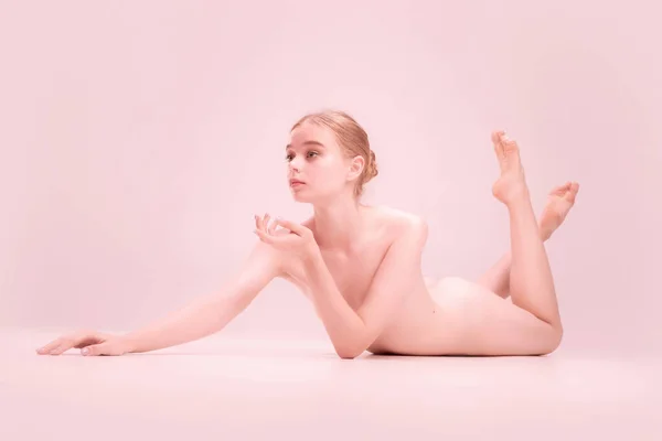 Gadis muda telanjang muda anggun berpose terisolasi di latar belakang studio merah muda. Konsep keindahan, kemurnian, kelembutan dan rahmat. — Stok Foto