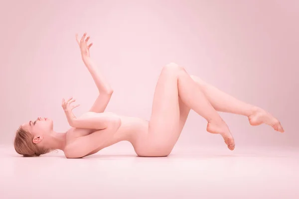 Graciosa frágil jovem menina bonita nua posando isolado no fundo do estúdio rosa. Conceito de beleza, pureza, ternura e graça. — Fotografia de Stock