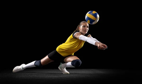 Giocatrice professionista femminile di pallavolo con palla isolata su sfondo nero. L'atleta, l'esercizio fisico, l'azione, lo sport, lo stile di vita sano, l'allenamento, il concetto di fitness. — Foto Stock