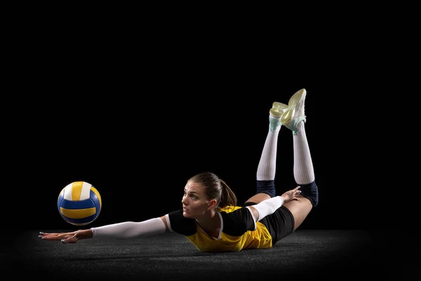 Giocatrice professionista femminile di pallavolo con palla isolata su sfondo nero. L'atleta, l'esercizio fisico, l'azione, lo sport, lo stile di vita sano, l'allenamento, il concetto di fitness. — Foto Stock