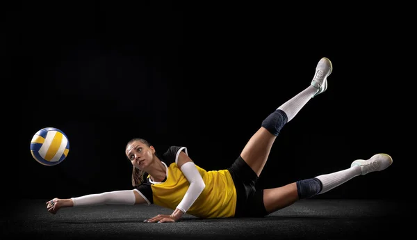 Vrouwelijke professionele volleybalspeler met bal geïsoleerd op zwarte studio achtergrond. De atleet, oefening, actie, sport, gezonde levensstijl, training, fitness concept. — Stockfoto