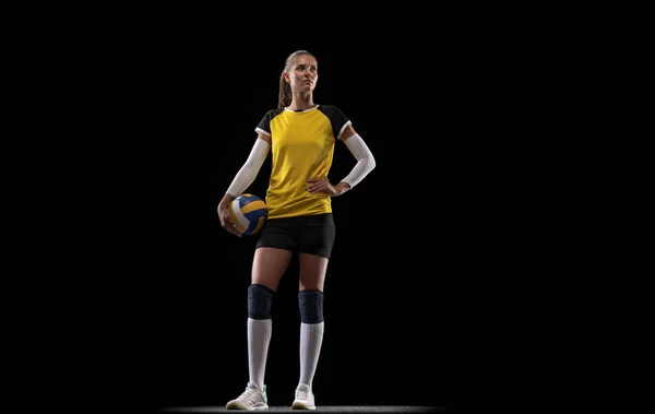 Jovem jogadora de voleibol feminina isolada no fundo do estúdio preto. Mulher em equipamentos esportivos e sapatos ou tênis treinamento e prática. — Fotografia de Stock