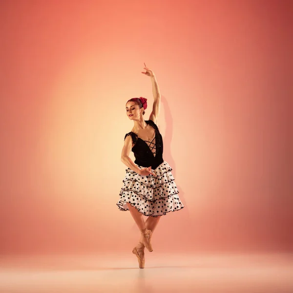 Jeune et incroyablement belle ballerine pose et danse au studio rouge plein de lumière. — Photo