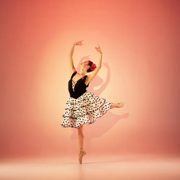 Jeune et incroyablement belle ballerine pose et danse au studio rouge plein de lumière. — Photo