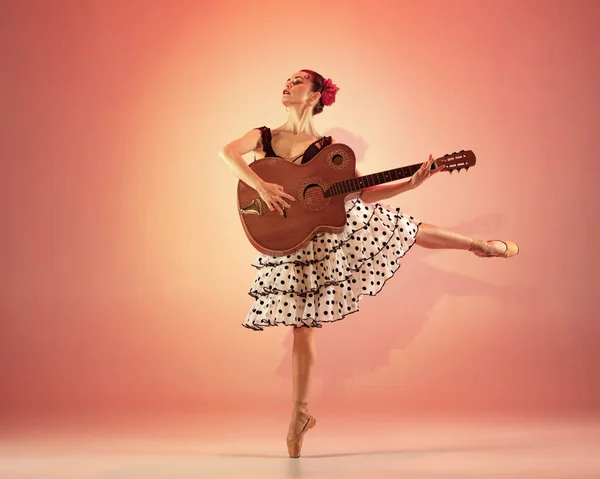 Jeune et incroyablement belle ballerine pose et danse au studio rouge plein de lumière. — Photo