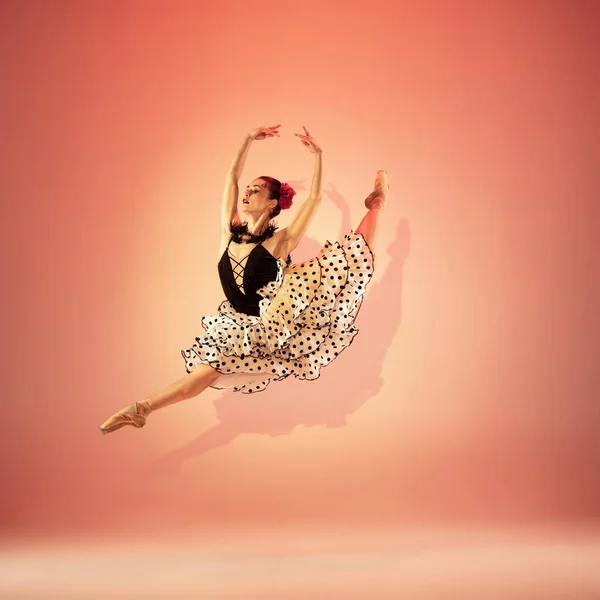 Jeune et incroyablement belle ballerine pose et danse au studio rouge plein de lumière. — Photo