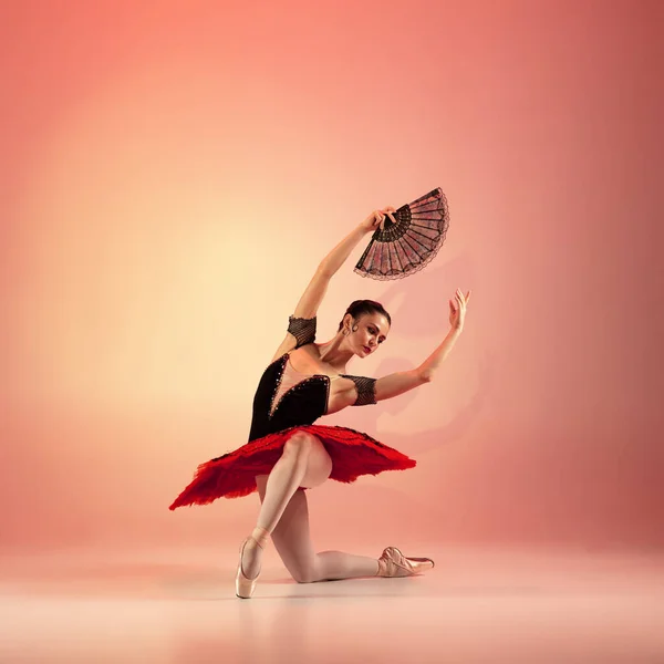 Giovane e incredibilmente bella ballerina è in posa e danza in studio rosso pieno di luce. — Foto Stock