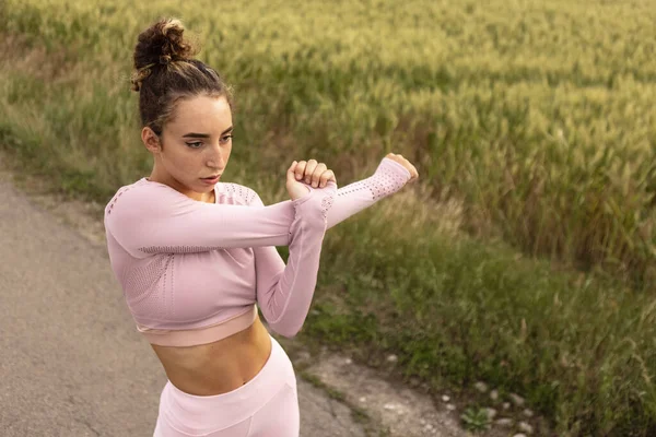 Jovem corredora, atleta está correndo na estrada em sol de verão. Bela mulher caucasiana a treinar, a ouvir música. Conceito de esporte, estilo de vida saudável, movimento, atividade. — Fotografia de Stock