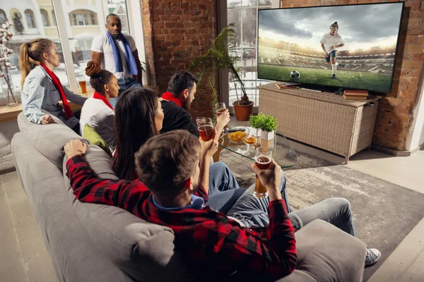 Gembira, bahagia sekelompok besar orang muda menonton pertandingan olahraga bersama di sofa di rumah. — Stok Foto