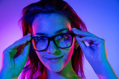 Kafkas genç kadın portresi neon renkli karanlık stüdyo arka planında. İnsan duyguları kavramı, yüz ifadesi.