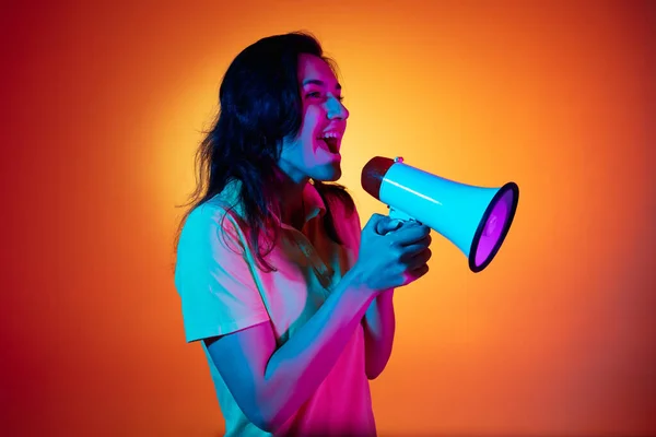 Caucasian young woman isolated on orange studio background in neon. Concept of human emotions, facial expression. — Stock Photo, Image