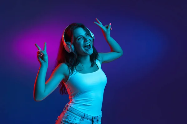 Kaukasische junge Frauen porträtieren auf dunklem Studiohintergrund in Neon. Konzept menschlicher Emotionen, Mimik. — Stockfoto