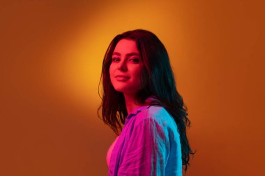 Kafkas genç kadın portresi neon renkli karanlık stüdyo arka planında. İnsan duyguları kavramı, yüz ifadesi.