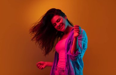 Kafkas genç kadın portresi neon renkli karanlık stüdyo arka planında. İnsan duyguları kavramı, yüz ifadesi.