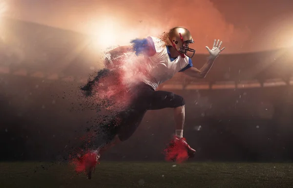 Young man american football player at stadium in motion in explosion of colored neon powder. Action, activity, sportlife concept. Flyer for ad, design. — Stock Photo, Image
