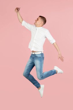 Genç beyaz adamın portresi pembe stüdyo arka planında izole edilmiş bir şekilde poz veriyor. Reklam için kopyalama alanı var. İnsan duyguları kavramı