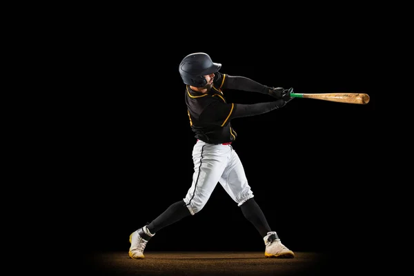 Profi baseball játékos, sportos egyenruhás dobó és baseball felszerelést játszó elszigetelt fekete stúdió háttér neon fényben. Csapatsport koncepció — Stock Fotó
