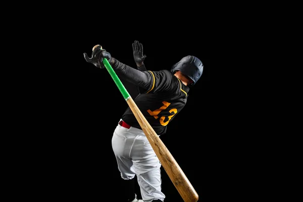 Professional baseball player, pitcher in sports uniform and equipment playing baseball isolated on black studio background in neon light. Rear view — Stock Photo, Image