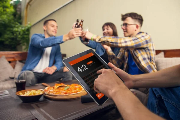 Weddenschappen plaatsen. Groep jongeren, gezelschap van vrienden die elkaar ontmoeten in bar, pub, buiten. Begrip vriendschap, vrijetijdsbesteding, emoties en sportevenement — Stockfoto