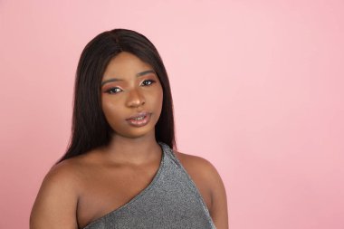 Pembe stüdyo arka planında Afrikalı genç kadın portresi. İnsan duyguları kavramı, yüz ifadesi, gençlik, satış, reklam.