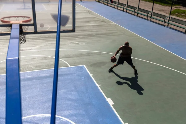 One african-american male basketball player training at street public stadium, sport court or palyground outdoors. Concept of healthy active lifestyle, motion, hobby. — Stock Photo, Image