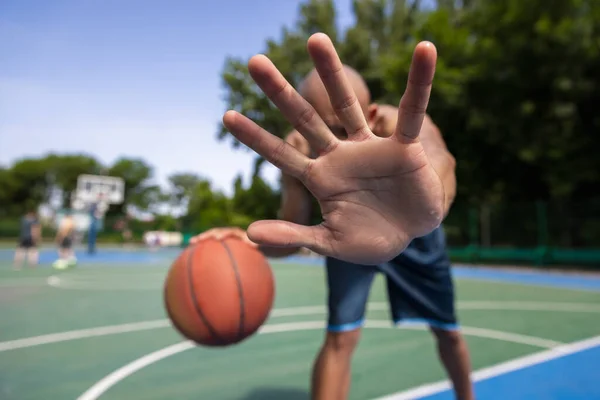 Pare, defesa. Jovem, jogador de basquete masculino africano muscular que joga basquete no estádio público de rua, quadra esportiva ou palyground ao ar livre. Jogos de esporte de verão. — Fotografia de Stock