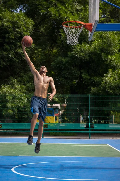 Jovem, jogador de basquete masculino africano muscular que joga basquete no estádio público de rua, quadra esportiva ou palyground ao ar livre. Jogos de esporte de verão. — Fotografia de Stock