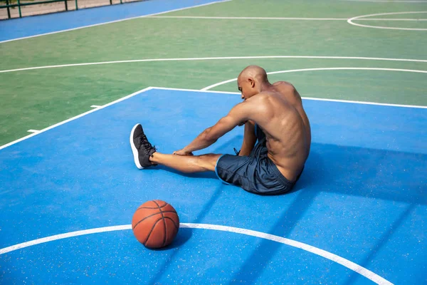 Joven hombre fuerte, jugador de baloncesto masculino practicando en el estadio público callejero, cancha deportiva o palyground al aire libre. Concepto de estilo de vida activo saludable, movimiento, hobby. —  Fotos de Stock