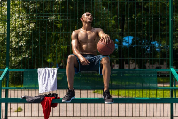 Joven hombre fuerte, jugador de baloncesto masculino practicando en el estadio público callejero, cancha deportiva o palyground al aire libre. Concepto de estilo de vida activo saludable, movimiento, hobby. —  Fotos de Stock