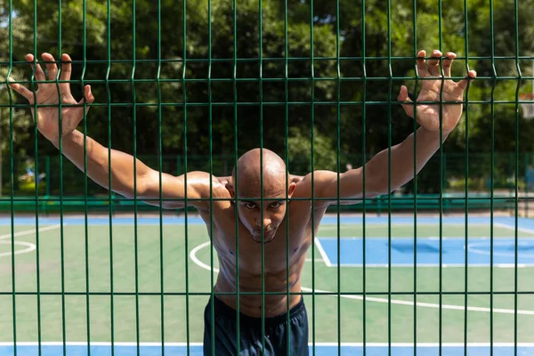 Entrenamiento. Joven hombre fuerte, jugador de baloncesto masculino entrenando en el estadio público callejero, cancha deportiva o palyground al aire libre. Concepto de estilo de vida activo saludable, movimiento, hobby. —  Fotos de Stock