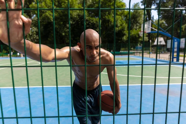 Ung stark man, manlig basketspelare tränar på gatan offentliga stadion, idrottsplan eller palyground utomhus. Begreppet hälsosam aktiv livsstil, rörelse, hobby. — Stockfoto