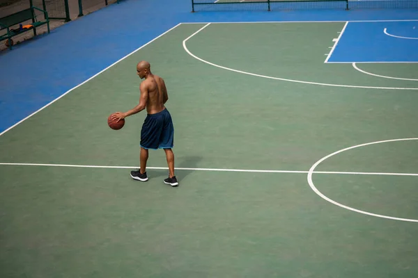 Vista superior do jovem, jogador de basquete masculino jogando basquete no estádio público de rua, quadra esportiva ou palyground ao ar livre. Jogos de esporte de verão. — Fotografia de Stock