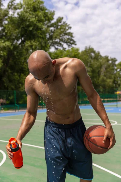 Joven hombre fuerte, jugador de baloncesto masculino entrenando en el estadio público callejero, cancha deportiva o palyground al aire libre. Concepto de estilo de vida activo saludable, movimiento, hobby. —  Fotos de Stock