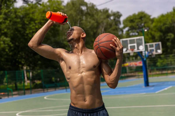 Joven hombre fuerte, jugador de baloncesto masculino entrenando en el estadio público callejero, cancha deportiva o palyground al aire libre. Concepto de estilo de vida activo saludable, movimiento, hobby. —  Fotos de Stock