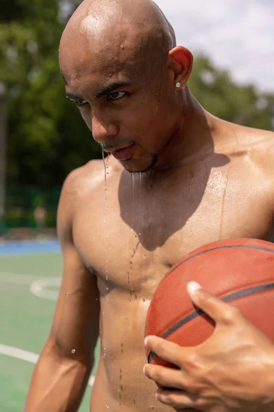 Primer plano joven, jugador de baloncesto africano masculino jugando baloncesto en el estadio público de la calle, pista de deporte o palyground al aire libre. Juegos de verano deporte. —  Fotos de Stock