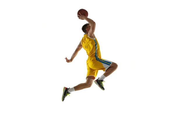 Vista lateral. Um jovem, jogador de basquete com um treinamento de bola isolado no fundo do estúdio branco. Conceito de publicidade. Apto atleta caucasiano pulando com bola. — Fotografia de Stock