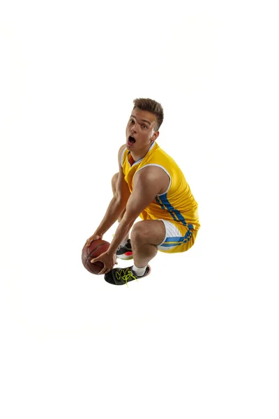 Hög vinkel syn på ung man, basketspelare med en boll träning isolerad på vit studio bakgrund. Reklamkoncept. Passform vit idrottsman hoppar med boll. — Stockfoto
