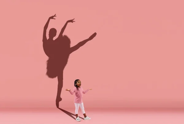 Childhood and dream about big and famous future. Conceptual image with girl and shadow of female ballet dancer on coral pink wall, background. — Stock Photo, Image