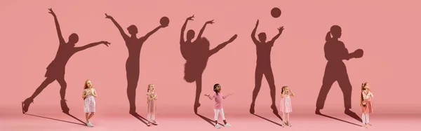 Kolaż. Marzy o wielkiej i sławnej przyszłości. Obraz koncepcyjny z małymi dziewczynkami i cieniami wysportowanych sportowców na jasnoróżowym, koralowym tle — Zdjęcie stockowe